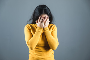 Wall Mural - sad woman hand in face on grey background