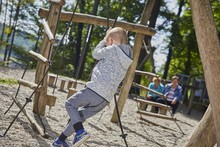 Little Boy Playing On The Horizontal Bars In The Playground