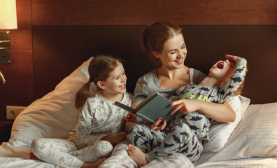 Wall Mural - evening family reading. mother reads children . book before going to bed .