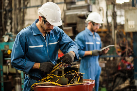 engineer manual workers standing in a aluminum mill and working together. used professional equipmen