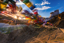 India, Jammu And Kashmir, Leh, Setting Sun Shining Through Prayer Flags Of Namgyal Tsemo Monastery