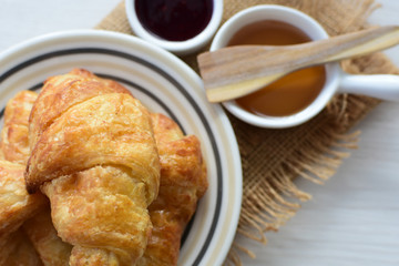 Small butter croissant, accompanied by honey