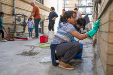 Boy Helping Neighbors Cleaning Apartment Brick Walls And Alley