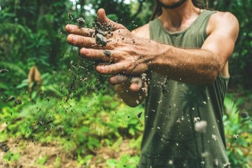 A gardening man dusting off his hands 