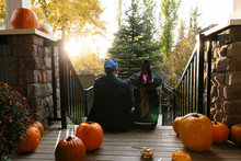 Father And Daughter In Halloween Costume On Steps Of Porch