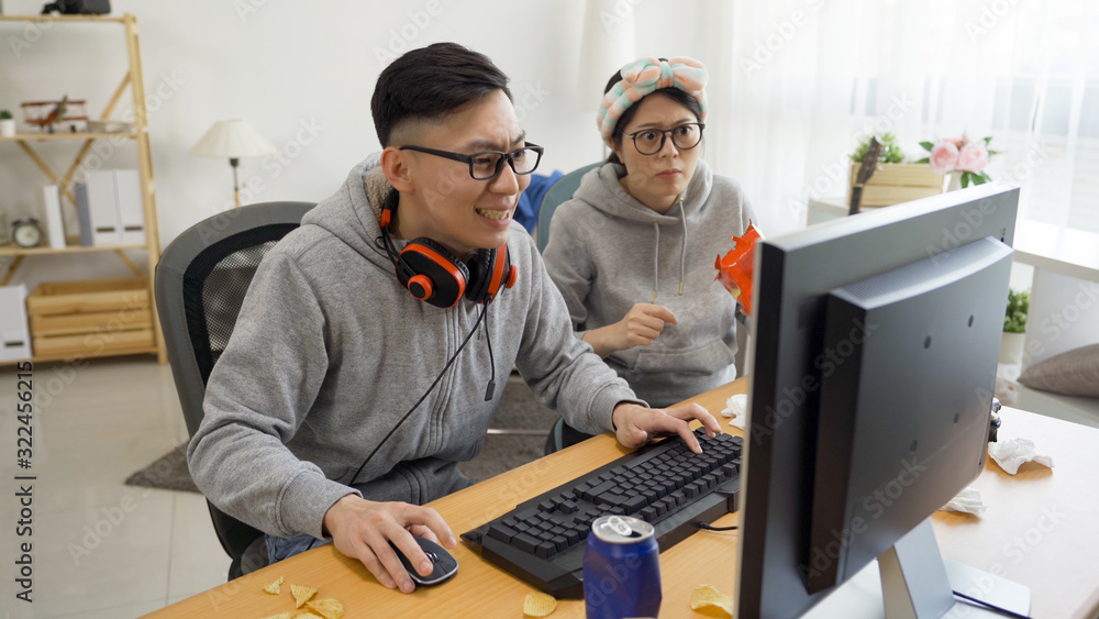 two nervous couple sitting at computer desktop having fun together ...