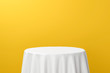 © Lemonsoup14 - White dinner table or empty pedestal display on vivid yellow background with elegant fabric. Blank stand for showing product. 3D rendering.
