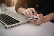 © NINENII - Male businessmen use credit cards to conduct financial transactions through phones, tablet, and laptop.