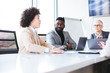 © Sanja - Three businesspeople in the conference room having a meeting. There are two women and a man.