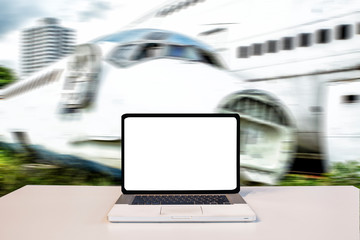 Laptop with blank screen on table with Coconut tree blur green nature in background. Technology concept.