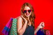 © kohanova1991 - Happy retro styled young woman with red hair and paper bags after shopping isolated on studio background. Seasonal sale, purchases, spending money on gifts concept