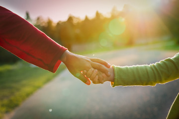 boy and little girl holding hands in sunset