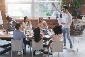 Canvas Print - Young manager cheering up his young business team