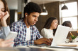© Prostock-studio - Afro student doing homework in college library