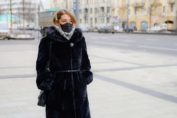 Wall Mural - young european woman in protective disposable medical black mask in city outdoor. concept protection of dangerous 2019-nCoV influenza coronavirus, mutated and spreading in China