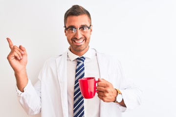 Canvas Print - Young handsome therapist man drinking coffee over isolated background very happy pointing with hand and finger to the side