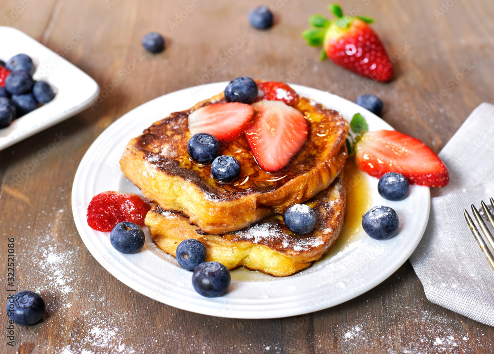 Delicious french toast with fresh fruits and maple sirup. Tasty breakfast scene or dessert with toast, strawberries, blueberries and powdered sugar. - obrazy, fototapety, plakaty 