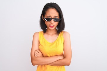 Sticker - Young beautiful chinese woman wearing thug life sunglasses over isolated white background skeptic and nervous, disapproving expression on face with crossed arms. Negative person.