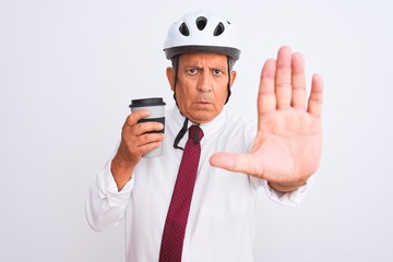 Wall Mural - Senior businessman wearing bike helmet drinking coffee over isolated white background with open hand doing stop sign with serious and confident expression, defense gesture