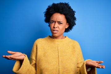 Sticker - Young beautiful African American afro woman with curly hair wearing yellow casual sweater clueless and confused with open arms, no idea concept.