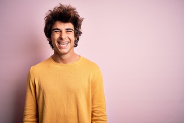 Young handsome man wearing yellow casual t-shirt standing over isolated pink background with a happy and cool smile on face. Lucky person.