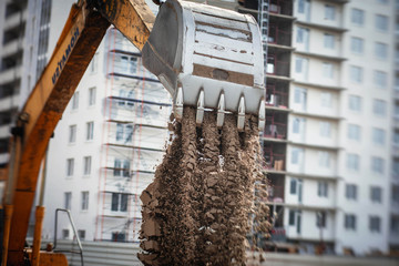 Wall Mural - Yellow heavy excavator excavating sand and working during road works, unloading sand during construction of the new road