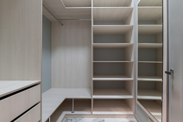 empty dressing room with wooden light furniture.