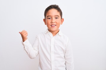 Sticker - Beautiful kid boy wearing elegant shirt standing over isolated white background smiling with happy face looking and pointing to the side with thumb up.