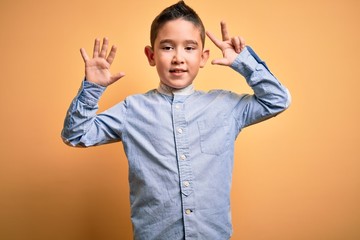 Canvas Print - Young little boy kid wearing elegant shirt standing over yellow isolated background showing and pointing up with fingers number eight while smiling confident and happy.