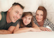 © Space_Cat - Happy family in bedroom: mother ,father and daughter under the blanket in bed at home