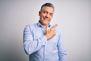 Poster - Middle age handsome grey-haired business man wearing elegant shirt over white background cheerful with a smile of face pointing with hand and finger up to the side with happy and natural expression