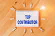 Handwriting text writing Top Contributor. Conceptual photo demonstrating who is knowledgeable in a particular category Colored clothespin papers empty reminder wooden floor background office
