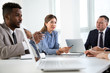 © chagin - Multy-ethnic group of business people working with computer at office