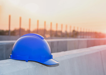 Wall Mural - blue hard safety helmet hat for safety project of workman as engineer or worker, on concrete floor on construction site background.