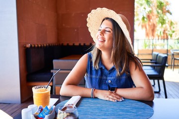 Wall Mural - Young beautiful woman sitting at restaurant enjoying summer vacation