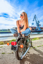An Attractive Girl On A Motorbike Posing Outside