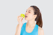 © NT_studio - Beautiful portrait young asian woman in sport with satisfied and holding and eat green apple isolated on white background, girl asia have shape and wellness, exercise for fit with health concept.