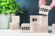 words step by step on wooden blocks, growth and progress concept