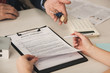 © LIGHTFIELD STUDIOS - cropped view of woman holding pen near clipboard with rental agreement lettering and agent with keys