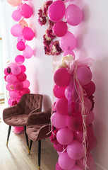 number 2 is made of flowers decorated on the wall, children's anniversary celebration; pink and red balloons on both sides