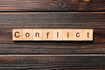 CONFLICT word written on wood block. CONFLICT text on wooden table for your desing, concept