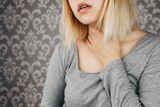 Fototapeta Panele - blonde woman holds on to a cold throat, has a cold, got sick, cropped photo