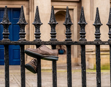Discarded Shoes Hanging On Railings