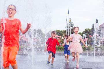 Canvas Print - Boys and girls are having fun in a city fountain