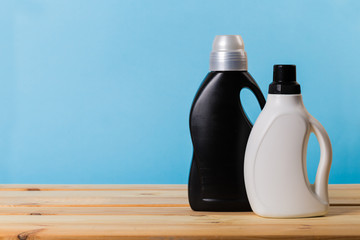 Cleaning product plastic container for house clean on wooden table and blue background . household chemicals