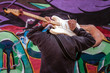 High school jazz band musician playing electric guitar by graffiti