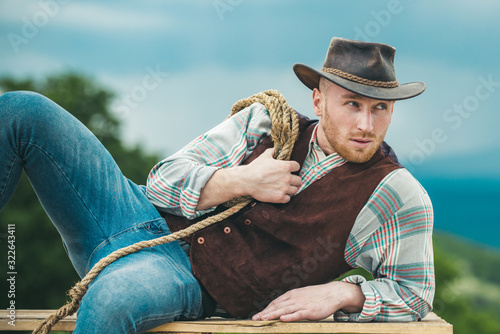 Sexy masculine stylish cowboy macho man holding lasso rope Tableau sur Toile