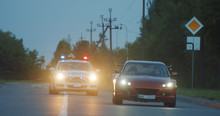 View Of Self-willed Young Man Driving On Modern Sports Car From The Police. Police Officer Cop Chasing A Thief Driving A Patrol Car On The Highway At Daytime. Police In Pursuit.