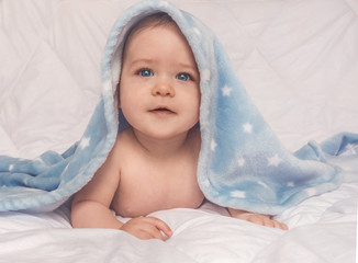 Sweet little blue eyes baby boy portrait with blue blanket on white background