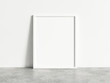© Washdog - Vertical empty white frame mock up on concrete floor. Blank frame mockup. 3d illustrations.